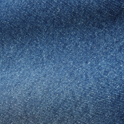 A close-up texture shot of blue denim fabric, showing the detailed twill weave and subtle fading.