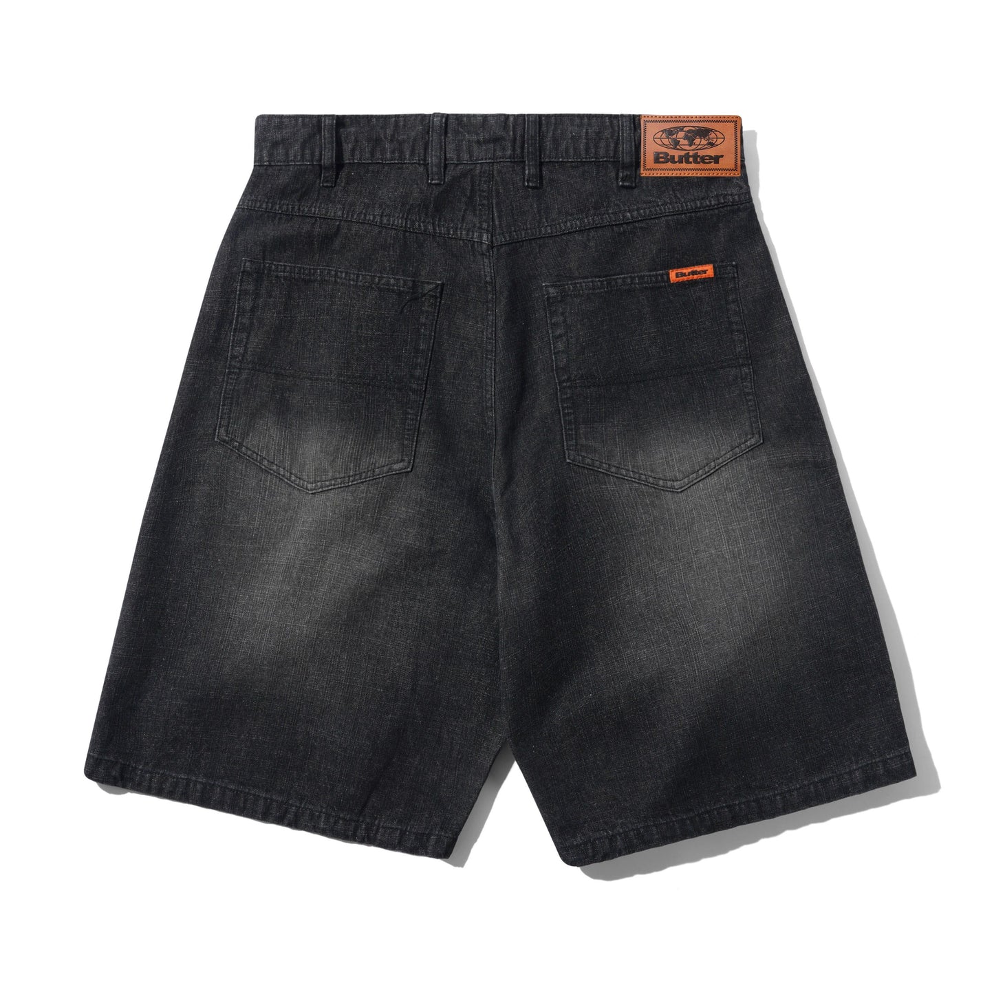 Back view of dark gray washed denim shorts with a visible Butter brand patch on the waistband and a small orange brand tab on the back pocket.