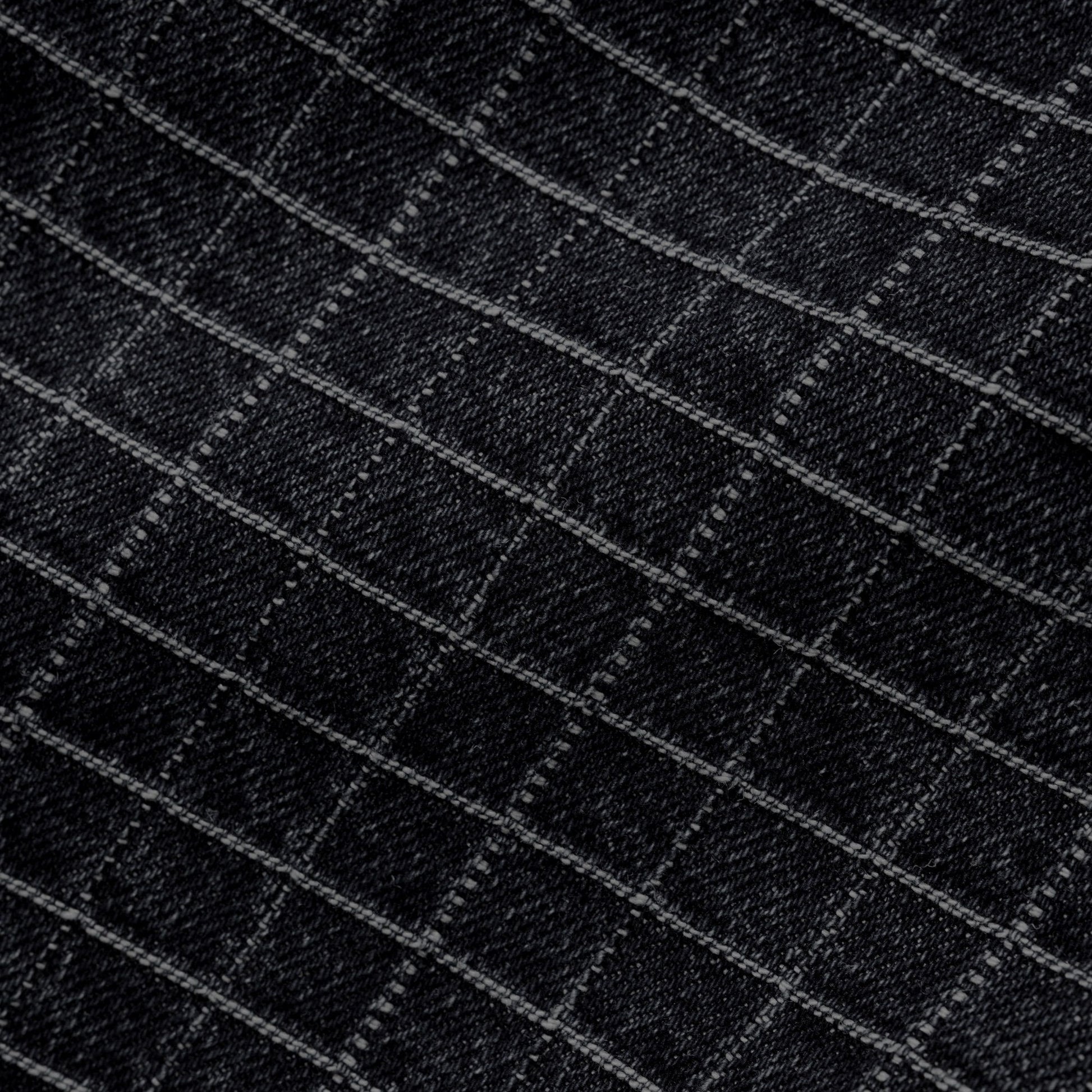 Close-up of a black fabric with a subtle diagonal grid pattern formed by lighter gray stitched lines.