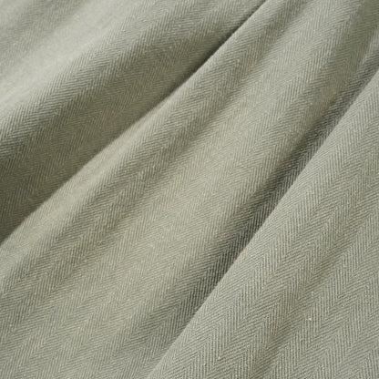 Close-up of textured green fabric with a subtle herringbone pattern