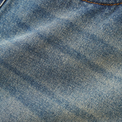 A close-up of blue denim fabric showing the detailed twill weave texture and a subtle light wash.