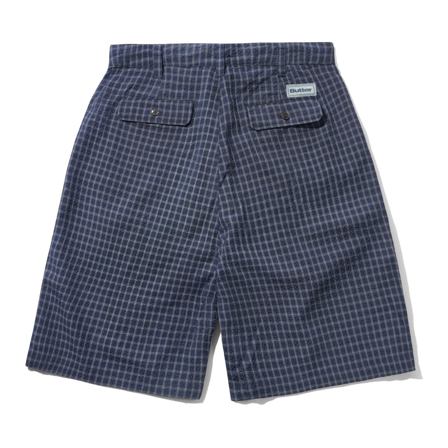 A pair of blue and white checkered shorts shown from the back, featuring two buttoned flap pockets and a small white brand label on the upper right side.
