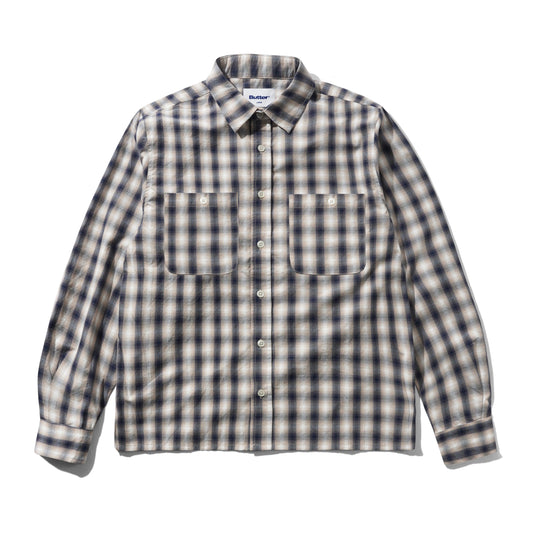 A long-sleeve button-up shirt with a classic plaid pattern in beige, white, and dark navy blue, featuring two buttoned chest pockets and a pointed collar.