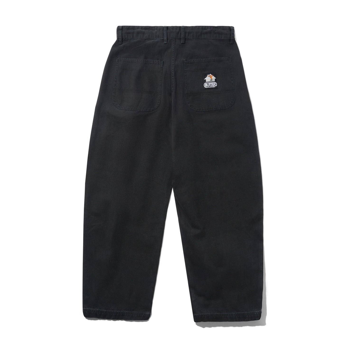 Black wide-leg work pants shown from the back, featuring a button waist, belt loops, two large back pockets, and a small sewn on Butter Goods logo on the upper right pocket.