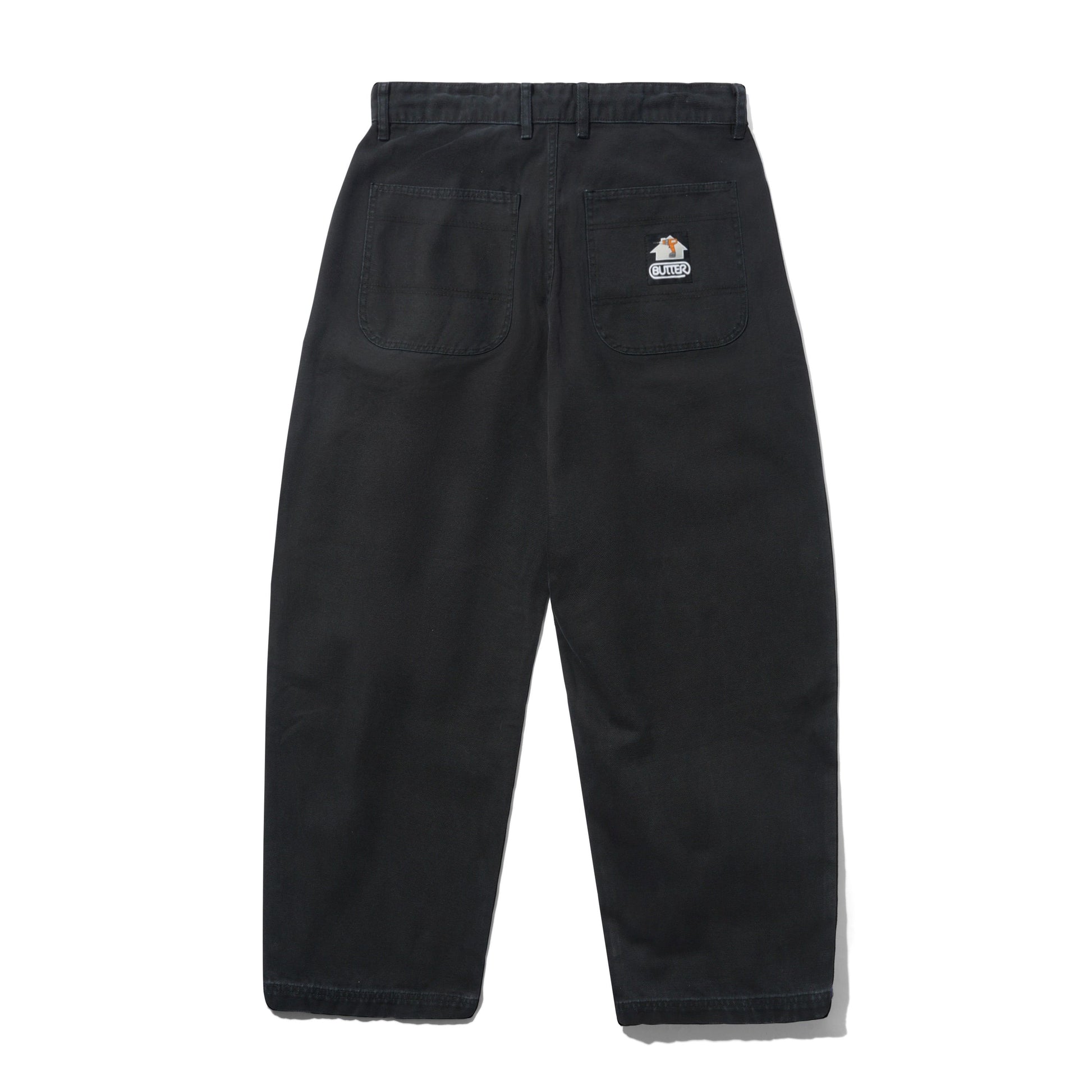 Black wide-leg work pants shown from the back, featuring a button waist, belt loops, two large back pockets, and a small sewn on Butter Goods logo on the upper right pocket.